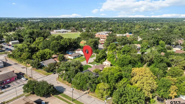 an aerial view of residential houses with outdoor space and trees