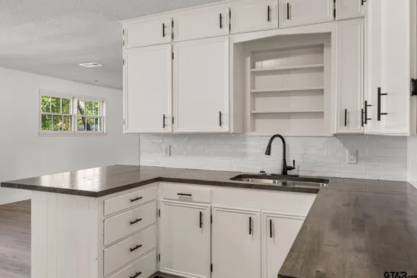 a kitchen with granite countertop white cabinets and white appliances