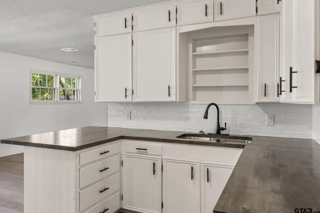 a kitchen with granite countertop white cabinets and white appliances