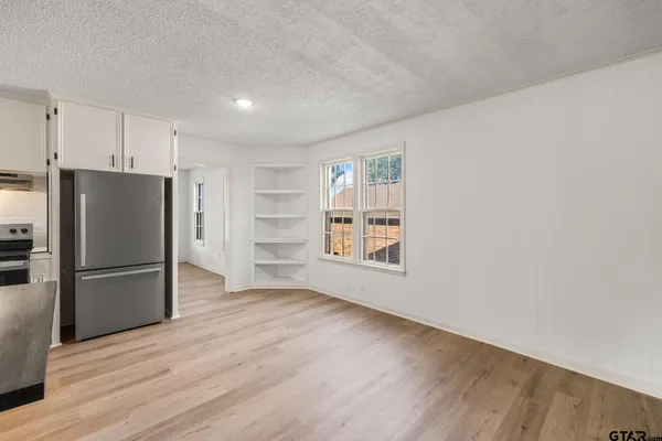 a view of a kitchen with a refrigerator a microwave and a window