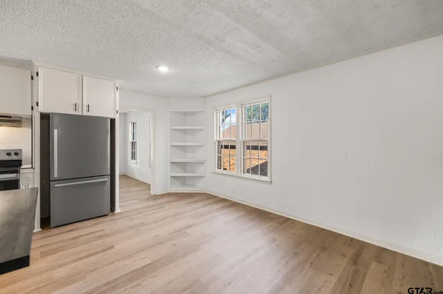 a view of a kitchen with a refrigerator a microwave and a window