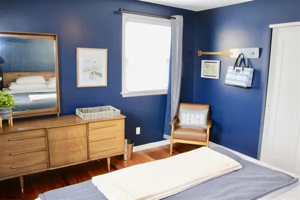 a bedroom with furniture and wooden floor