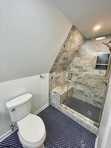 a bathroom with a toilet and a shower