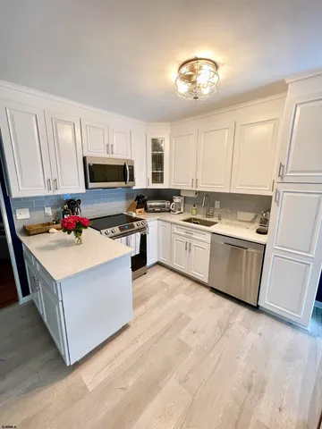a kitchen with kitchen island a white cabinets and white appliances