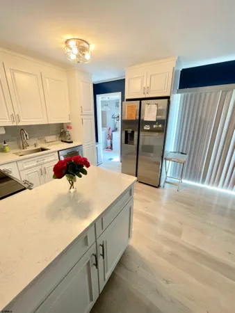 a kitchen with kitchen island a stove a refrigerator and a sink