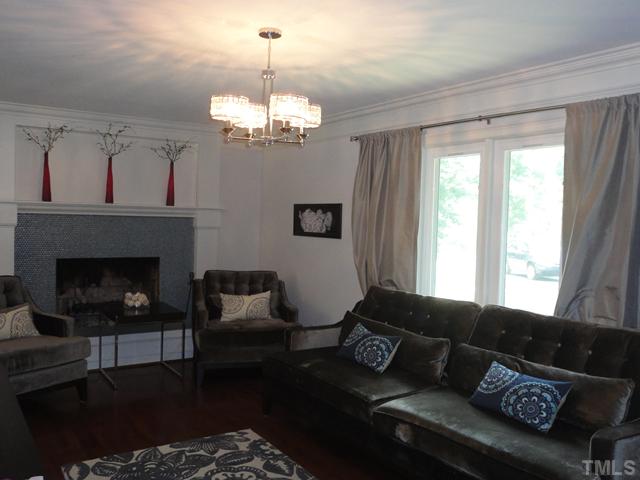 10232 Baileywick Road Raleigh, NC 27613 - Photo 6 of 24 a living room with furniture chandelier and a fireplace