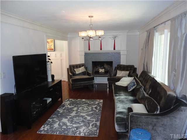 10232 Baileywick Road Raleigh, NC 27613 - Photo 7 of 24 a living room with furniture a flat screen tv and a fireplace