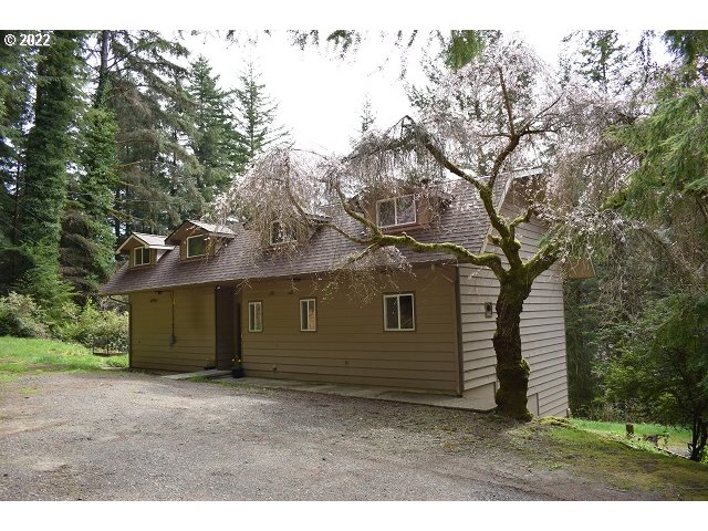 604 Thorton Oar Lane Reedsport, OR 97467 - Photo 1 of 32 a backyard of a house with a garden and tree