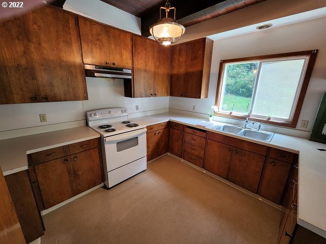 604 Thorton Oar Lane Reedsport, OR 97467 - Photo 13 of 32 a kitchen with stainless steel appliances granite countertop a sink a stove and a refrigerator
