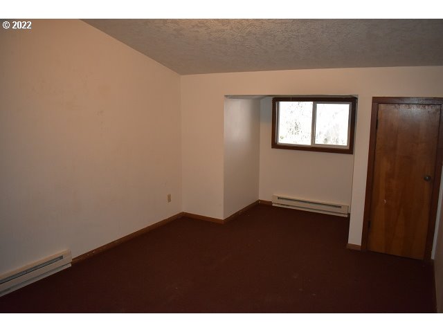 604 Thorton Oar Lane Reedsport, OR 97467 - Photo 28 of 32 a view of an empty room with wooden floor and a window
