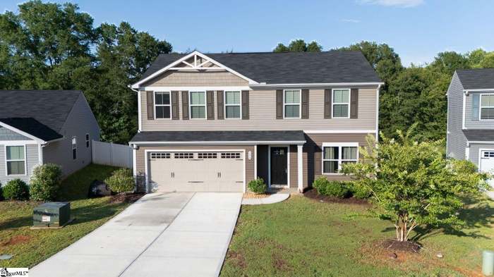 This two-story residence features a two-car garage, manicured lawn, and a classic black front door.