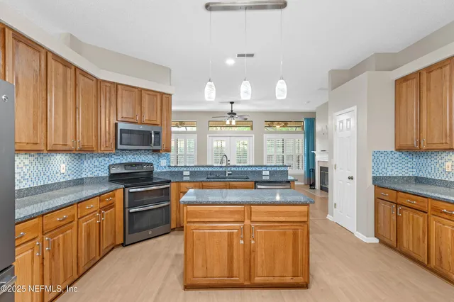 a kitchen with stainless steel appliances granite countertop a refrigerator a sink dishwasher a stove with white cabinets