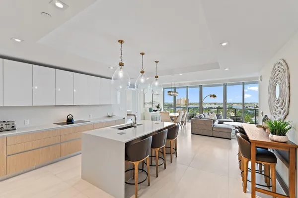 a large white kitchen with a large window and stainless steel appliances