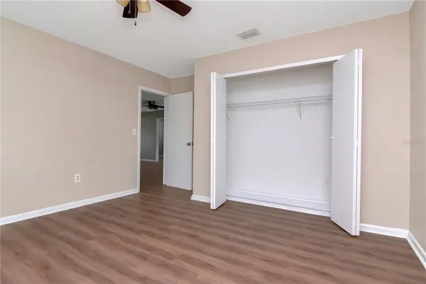an empty room with wooden floor and closet