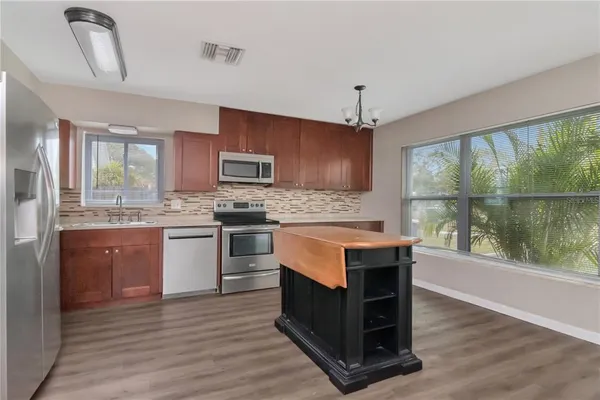 a kitchen with a stove a sink and a microwave