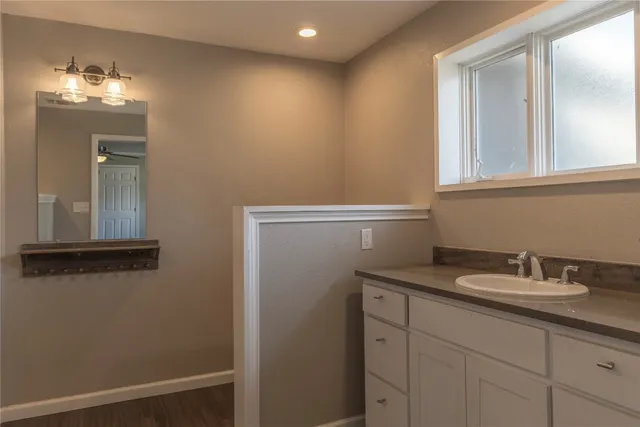 a bathroom with a sink a light fixture and a mirror