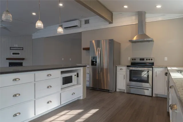 a kitchen with a refrigerator and a stove top oven