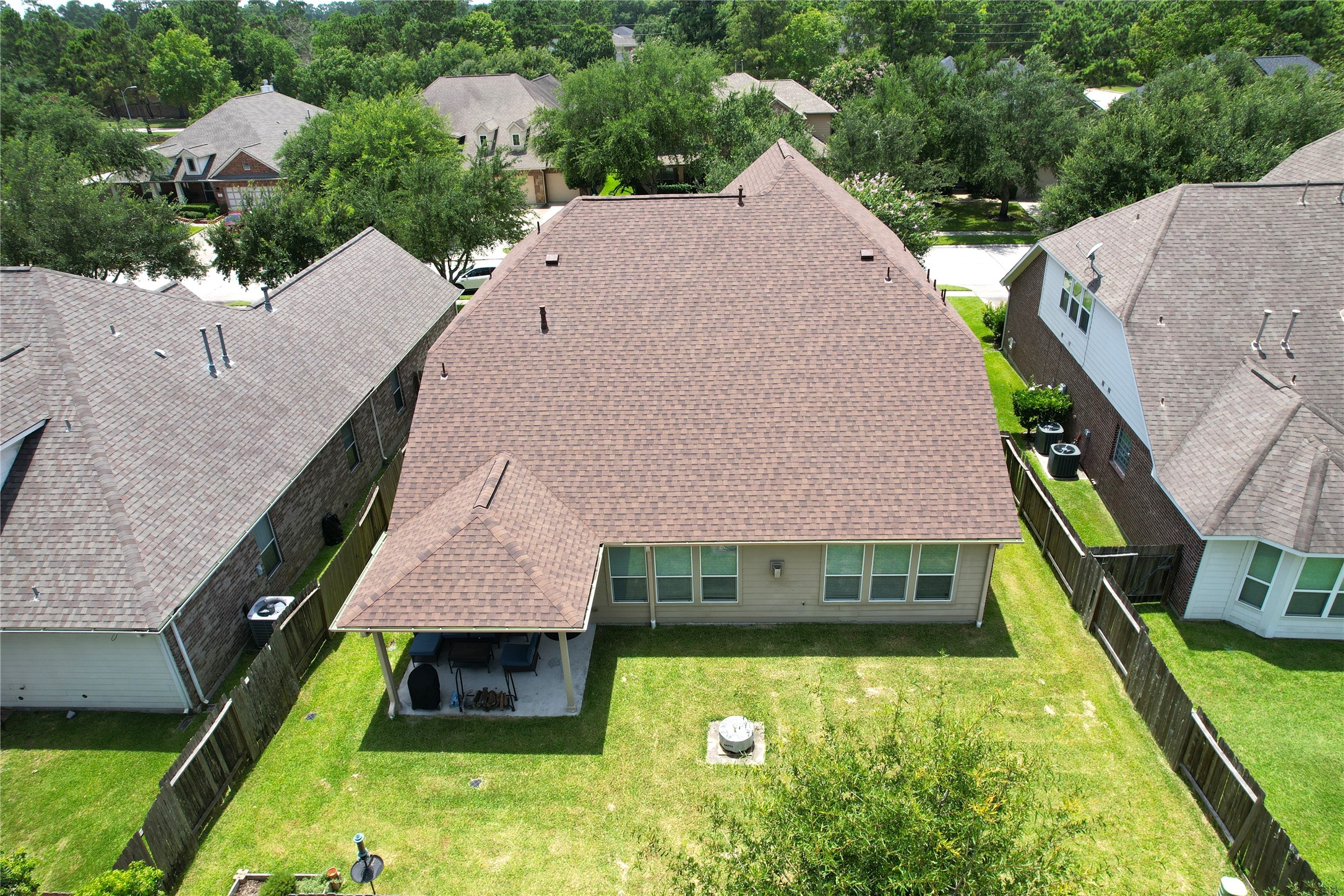 17402 Rainer Valley Lane Humble, TX 77346 - Photo 26 of 33 This aerial photo showcases a well-maintained single-story home with a spacious, fenced backyard. The property features a covered patio area, perfect for outdoor activities, and is situated in a neighborhood with mature trees, offering a sense of privacy and tranquility.