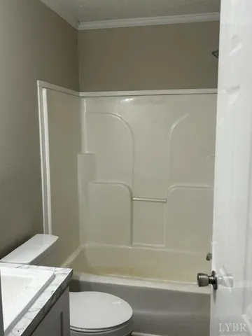 a bathroom with a granite countertop bathtub shower sink vanity and toilet