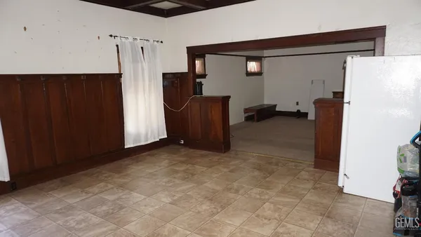 a view of a livingroom with furniture and a refrigerator