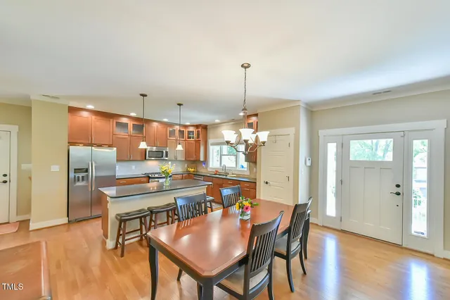a dining room with furniture a chandelier and wooden floor