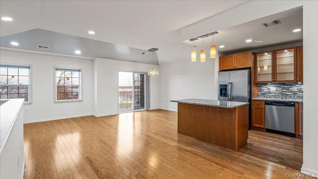 a kitchen with stainless steel appliances granite countertop a stove and a wooden floors