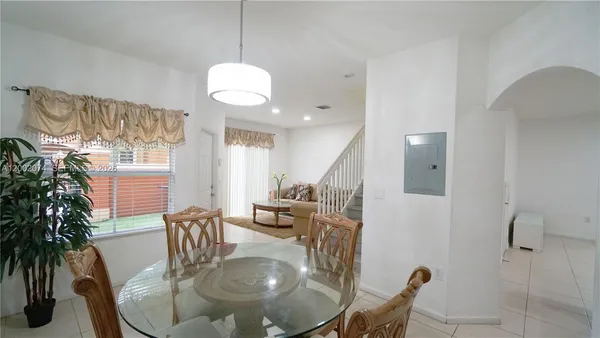 a dining room with furniture a chandelier and wooden floor