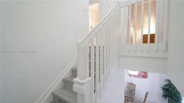 a view of staircase with white walls and a window
