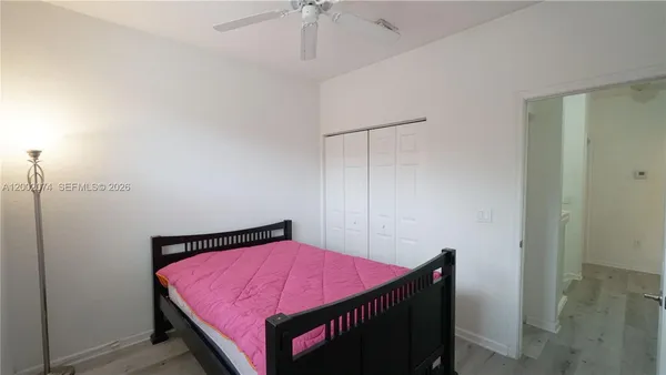 a bedroom with a bed and a chandelier fan