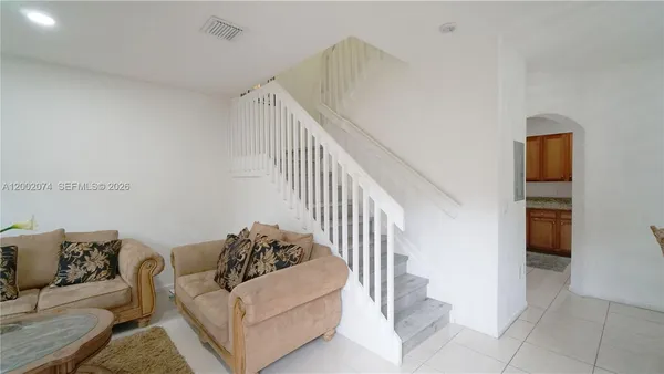 a living room with furniture and stairs
