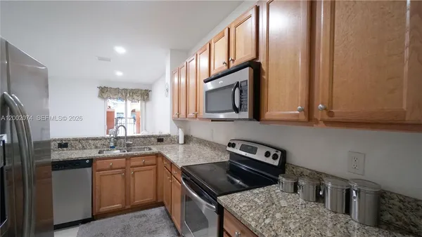 a kitchen with stainless steel appliances granite countertop a sink stove and refrigerator