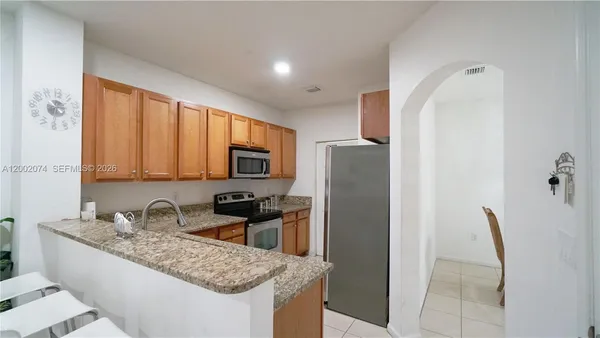 a kitchen with granite countertop a refrigerator and a sink