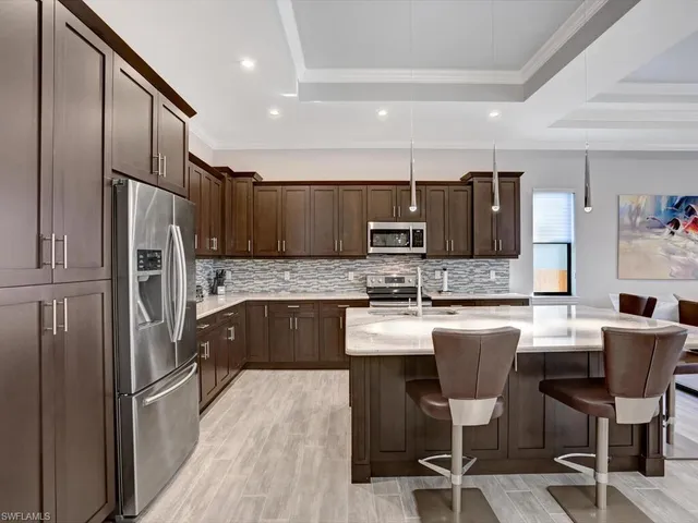 a kitchen with kitchen island granite countertop stainless steel appliances cabinets a sink and a counter top space