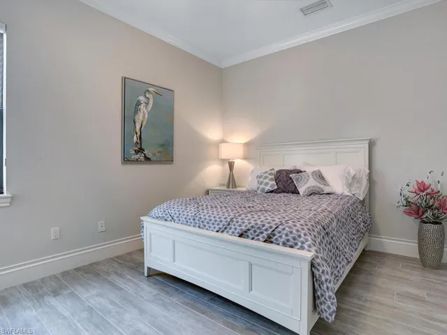 a bedroom with a bed and a potted plant