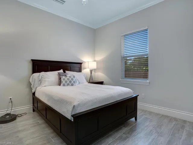 a bed sitting in a bedroom next to a window