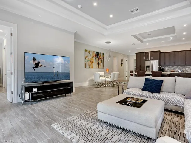 a living room with furniture a rug and kitchen view