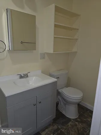 a bathroom with a toilet sink and mirror