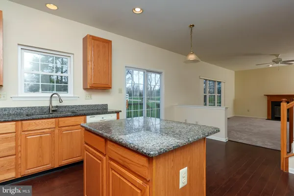 a kitchen with granite countertop kitchen island a sink appliances and a counter space