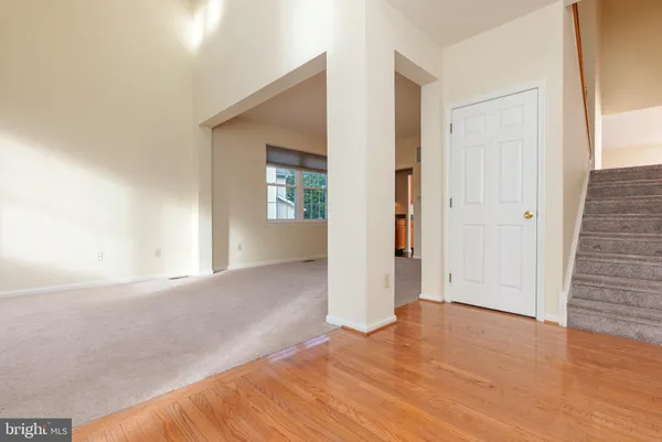 a view of a big room with wooden floor and windows
