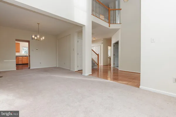 an empty room with staircase and a ceiling fan