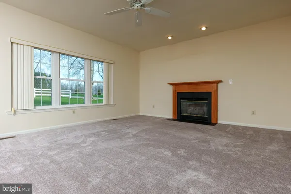 an empty room with a fireplace and windows