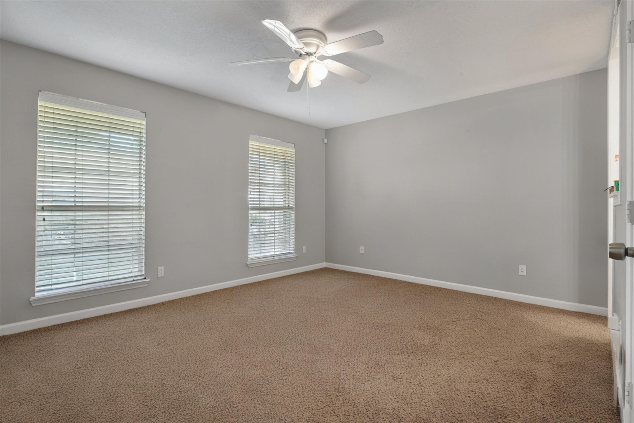 18230 Caprice Lane Houston, TX 77058 - Photo 13 of 34 an empty room with windows and ceiling fan