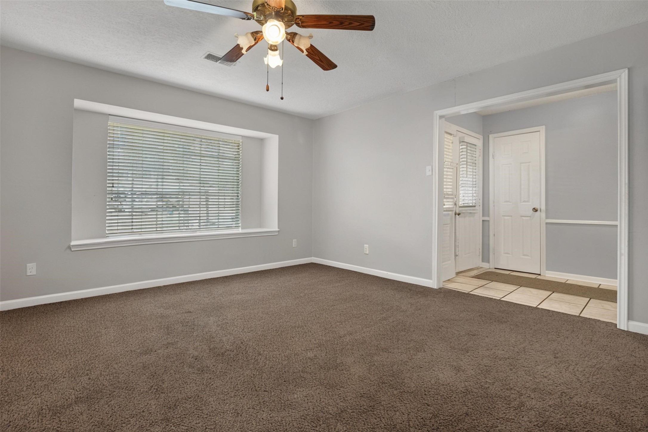 18230 Caprice Lane Houston, TX 77058 - Photo 27 of 34 an empty room with windows and chandelier fan