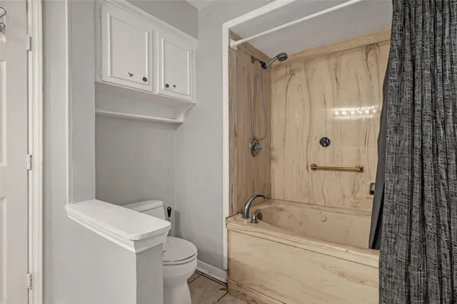 a bathroom with a tub a toilet and a shower