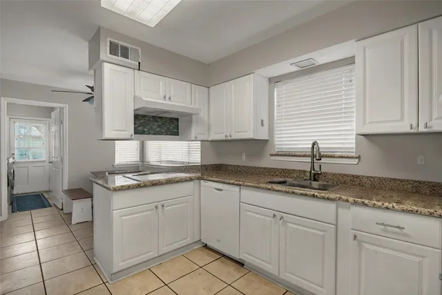 a kitchen with granite countertop white cabinets and white appliances