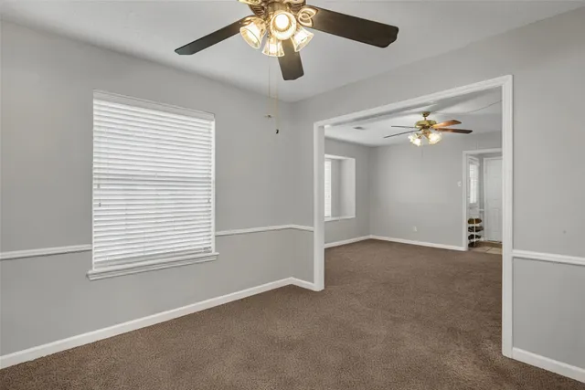 a view of a livingroom with a ceiling fan and window