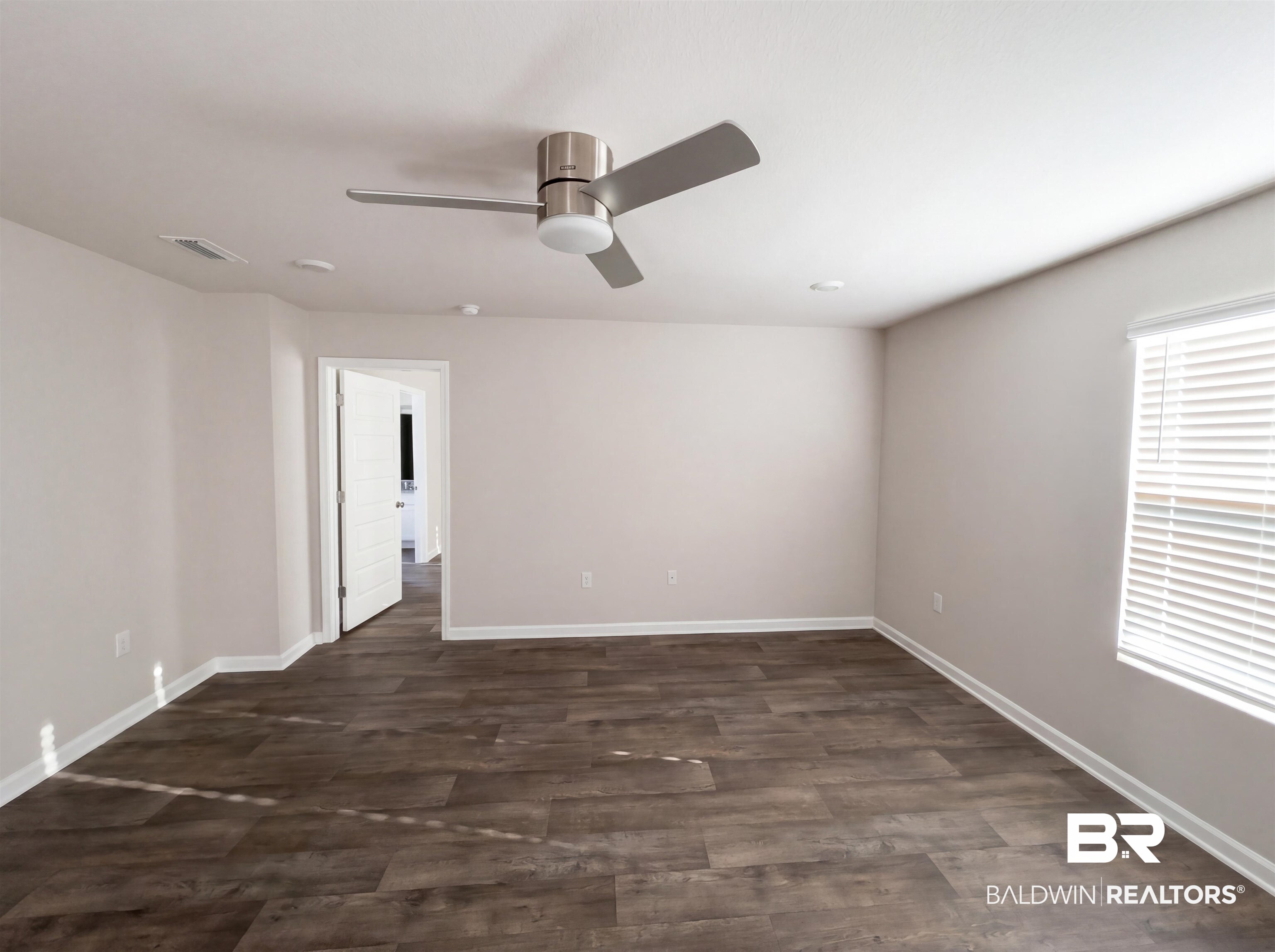 7453 Brompton Drive Foley, AL 36535 - Photo 10 of 15 Spacious interior room featuring wood-finish flooring, light neutral wall paint, and white baseboards