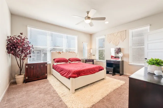 a spacious bedroom with a bed and a chandelier