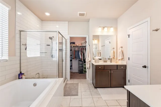 a bathroom with a tub a sink shower and mirror