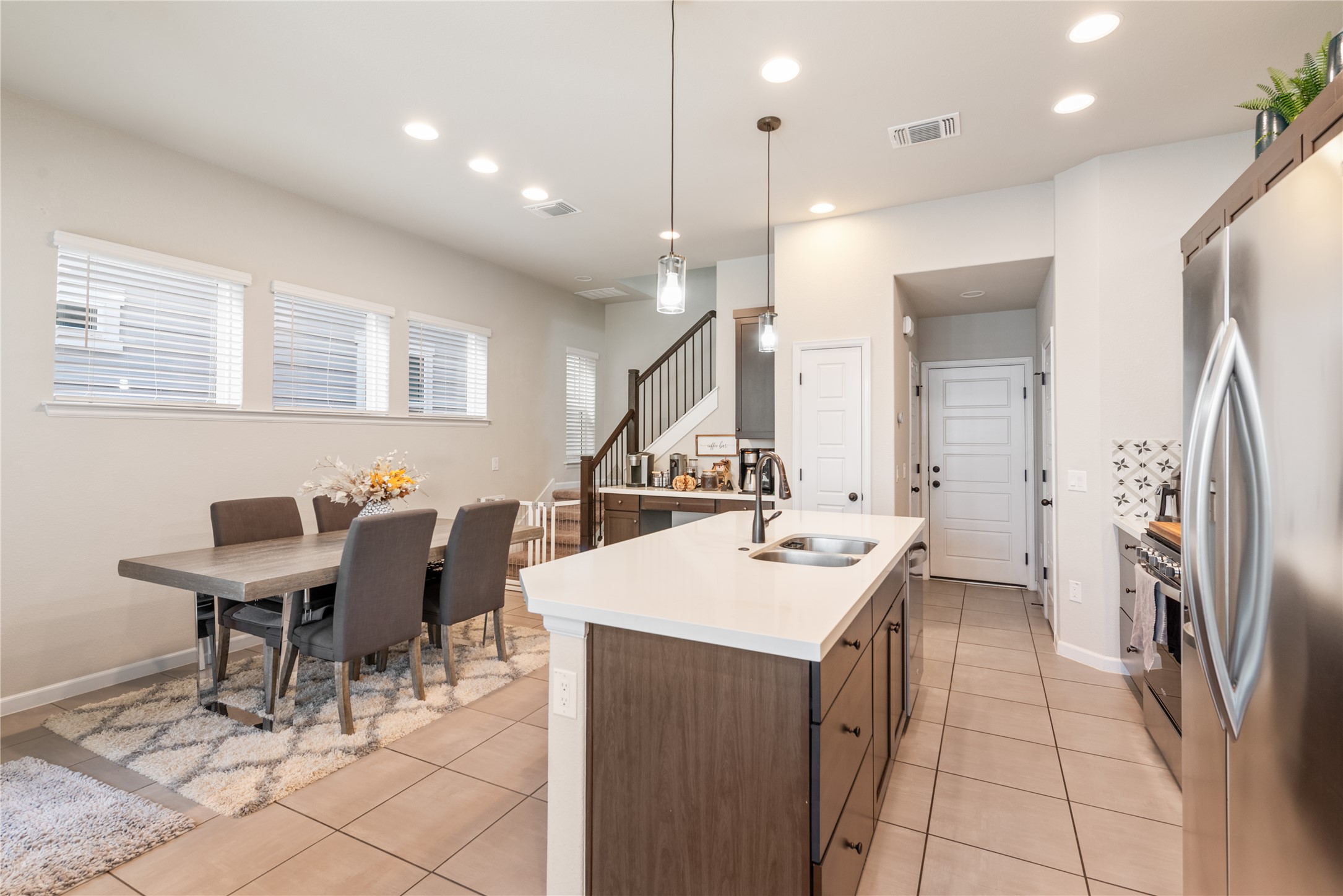 13602 Terrett Trace, Unit 102 Austin, TX 78717 - Photo 6 of 23 a kitchen with a sink a refrigerator and chairs